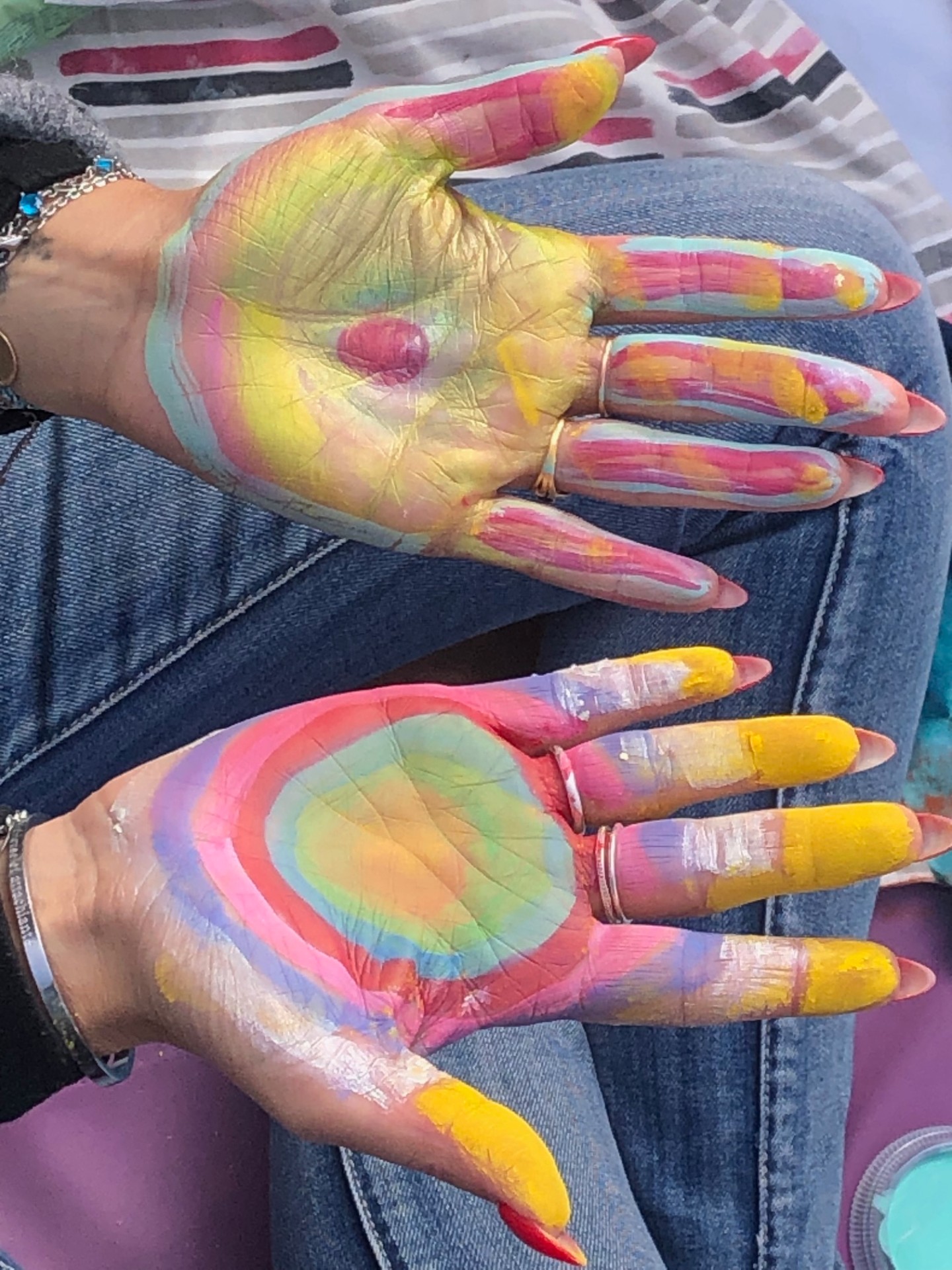 Mains peintes de couleurs vibrantes — geste de soin